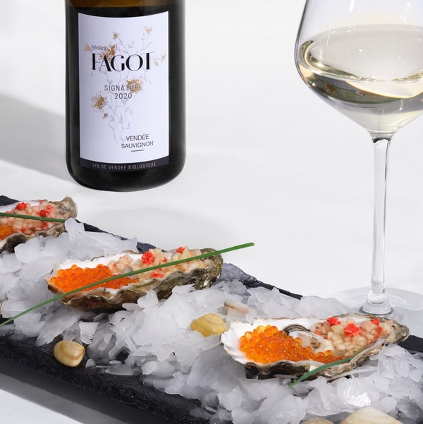 Bottle Signature Blanc du Vignoble Fagot next to an oyster