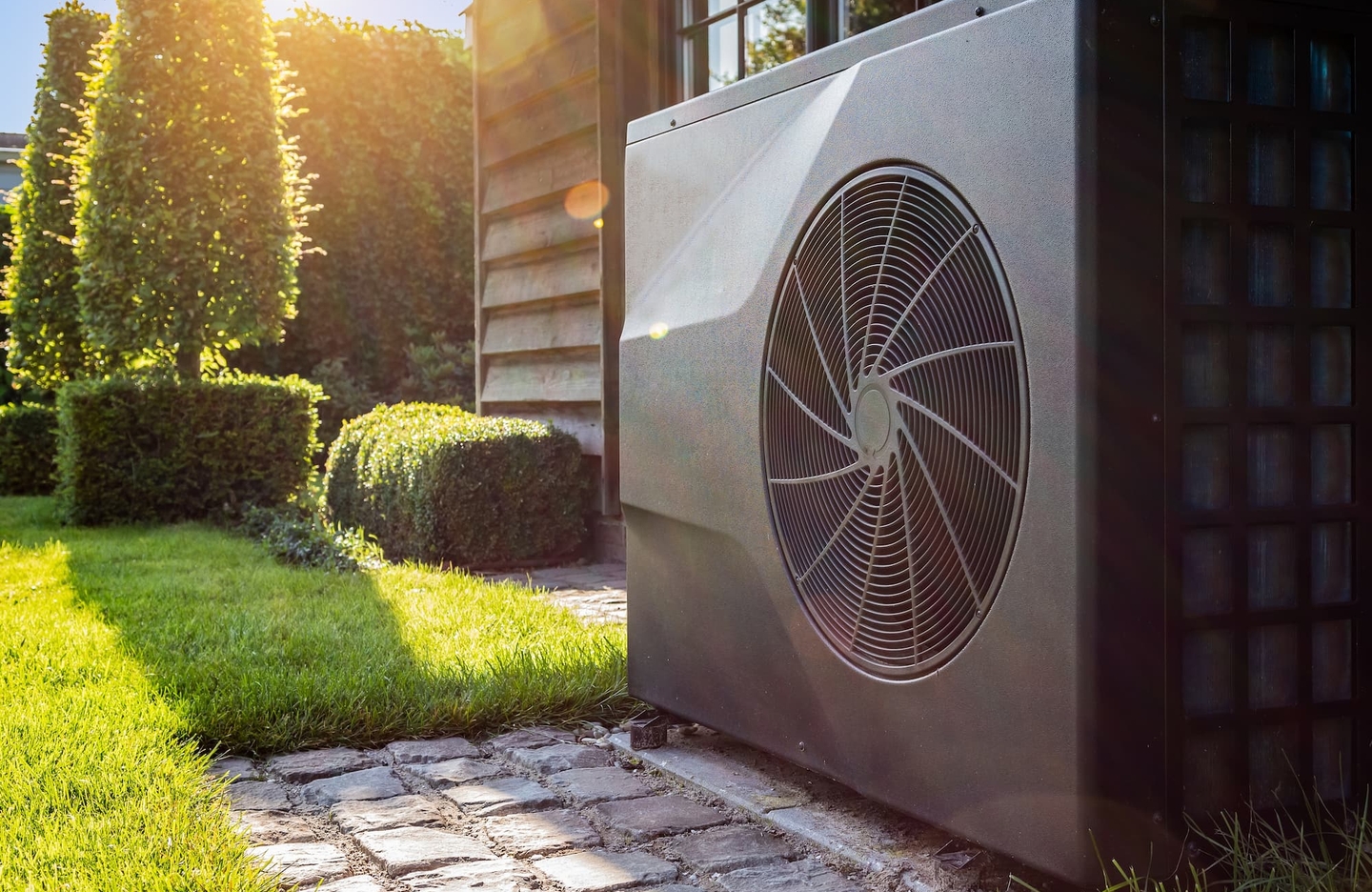 Unité extérieure de pompe à chaleur installée dans un jardin, dépannage chauffage en Vendée