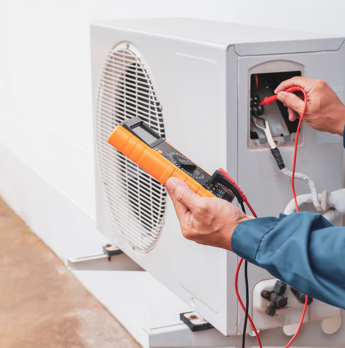 Technicien contrôlant l’unité extérieure d’une climatisation lors d’un entretien en Vendée