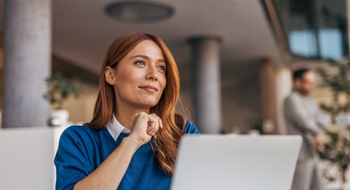 Femme réfléchissant devant son ordinateur portable