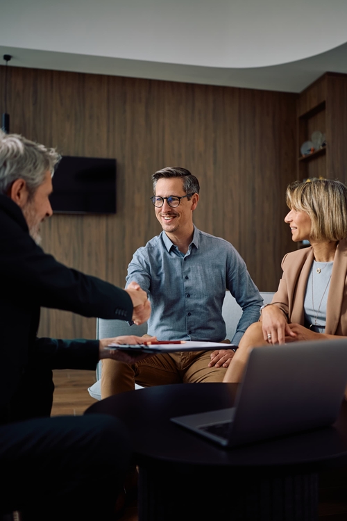 Poignée de main entre un conseiller DBI Patrimoine et ses clients en rendez-vous