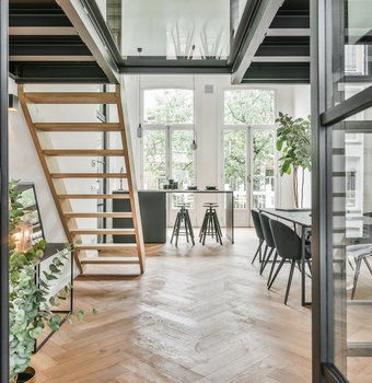Intérieur d'une extension de maison avec escalier bois et double hauteur