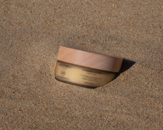 Creme de soin Artemia Cosmétiques posée sur le sable
