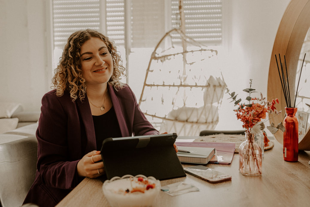 Clothilde, assistante indépendante CloAssist', souriante à son bureau devant une tablette