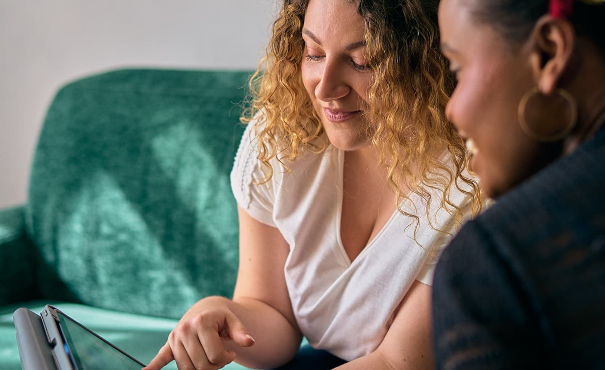 Clothilde en rendez-vous avec une cliente, lui montrant des informations sur sa tablette
