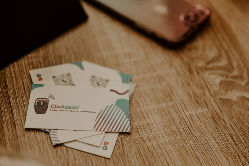 Cartes de visite CloAssist' posées sur une table en bois
