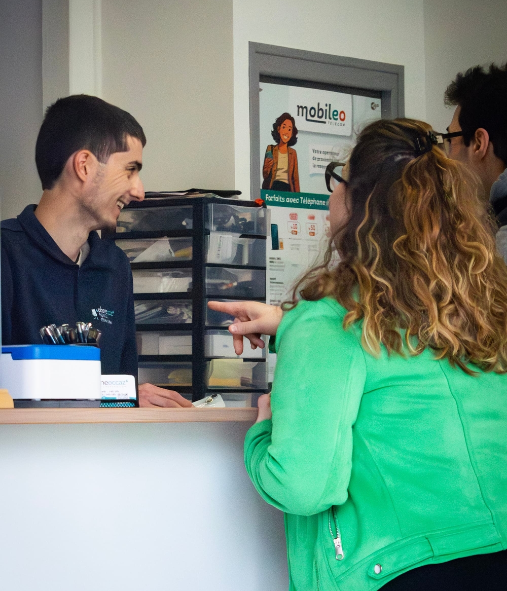 Yohan échangeant avec des clients au comptoir de la boutique Phone Occaz