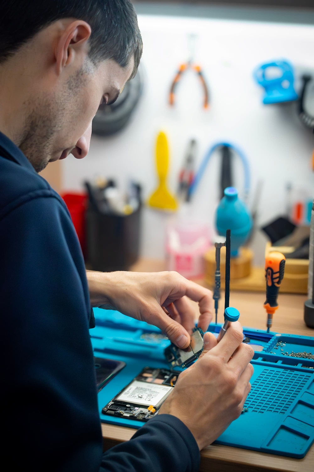 Yohan de Phone Occaz réparant un smartphone dans son atelier à Aizenay