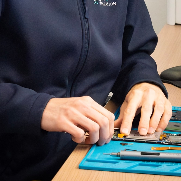 Yohan répare un smartphone dans l'atelier Phone Occaz