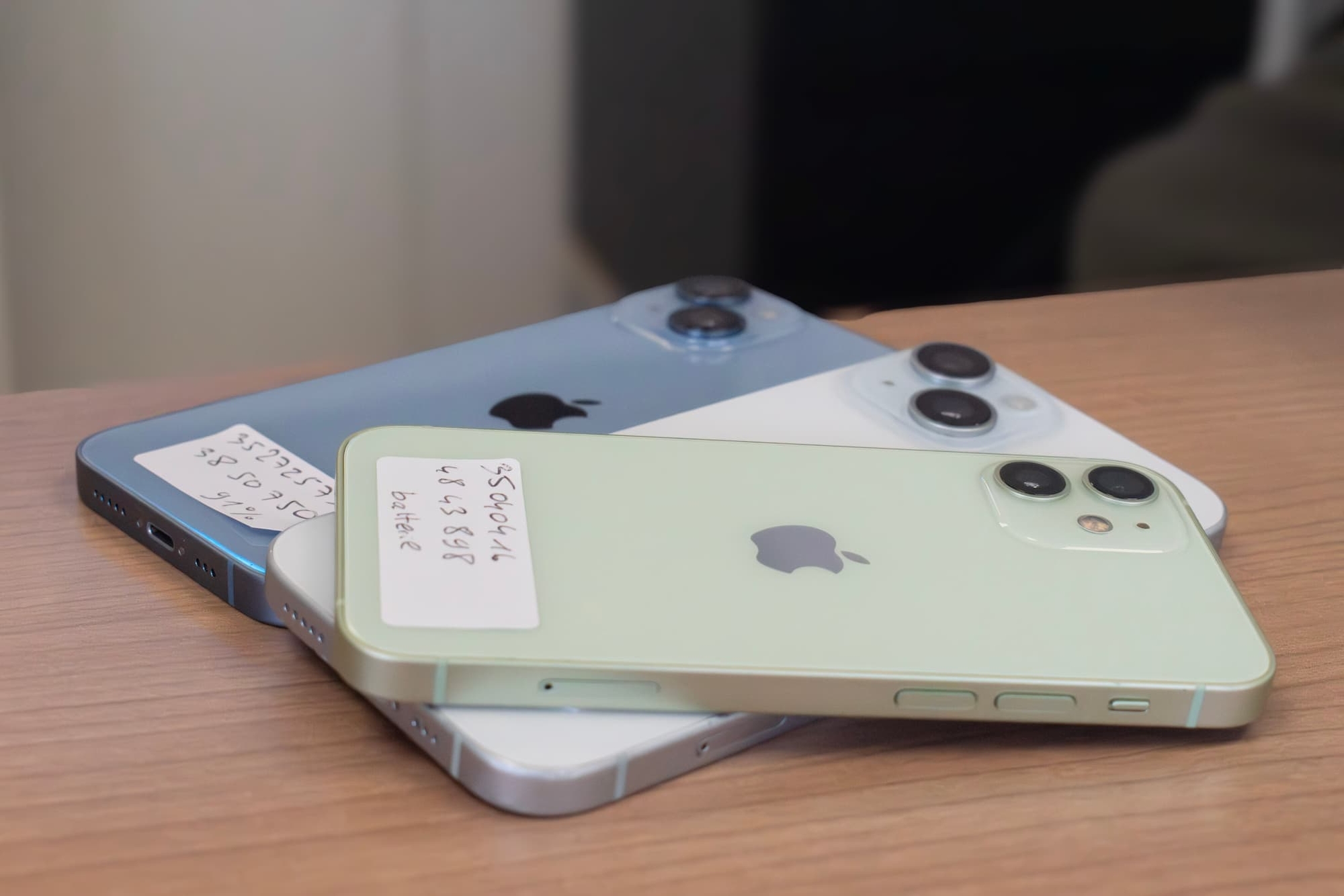 Téléphones reconditionnés étiquetés posés sur l'établi de l'atelier Phone Occaz