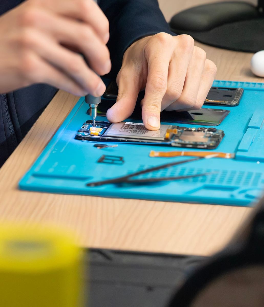 Remplacement d'une pièce sur un smartphone ouvert dans l'atelier Phone Occaz
