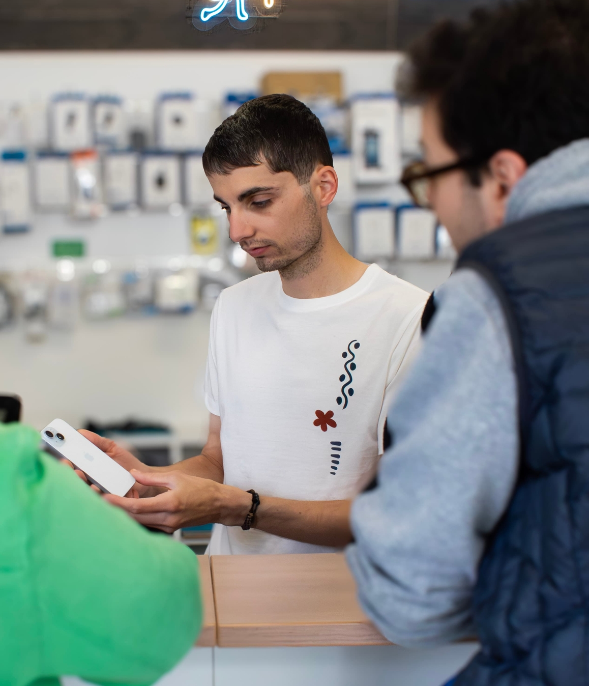 Yohan conseille un professionnel sur un smartphone dans la boutique Phone Occaz d'Aizenay