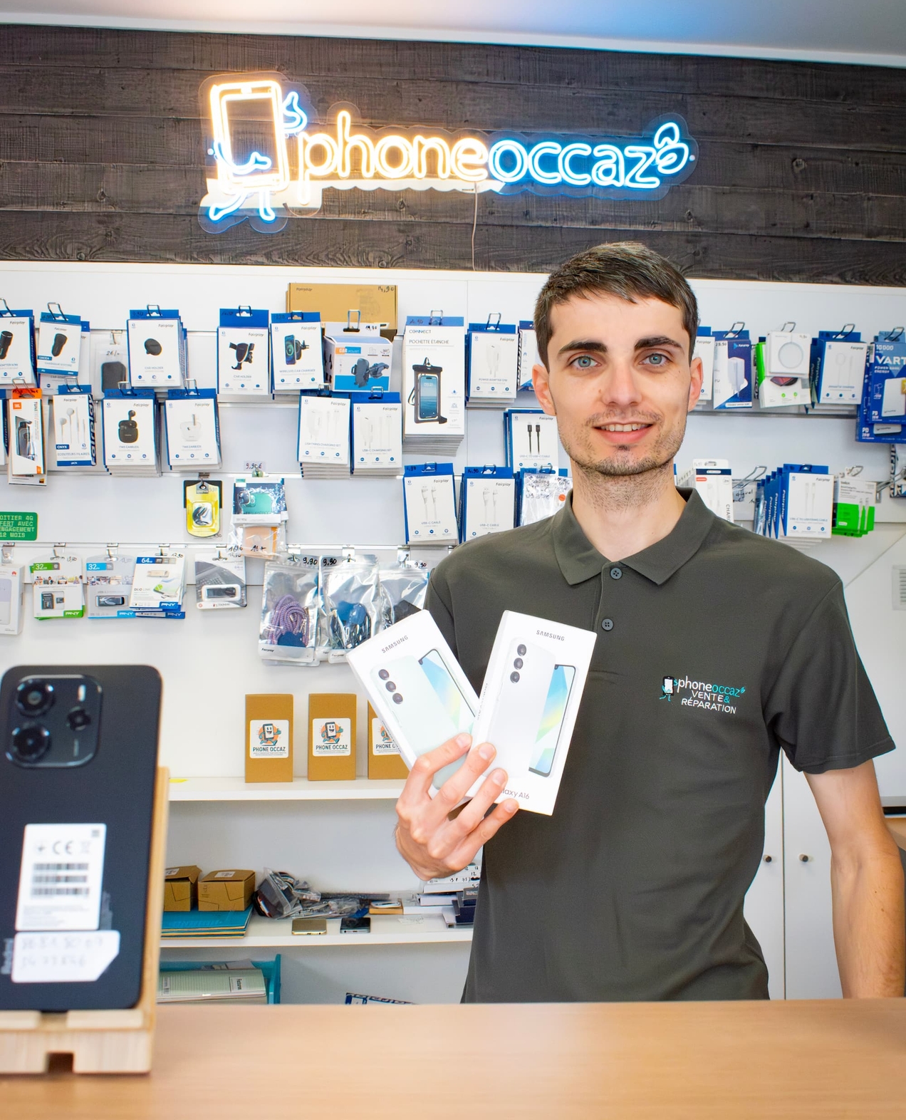 Yohan de Phone Occaz présente des téléphones dans sa boutique d'Aizenay