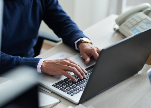 Gros plan sur la main d'un homme sur son clavier d'ordinateur