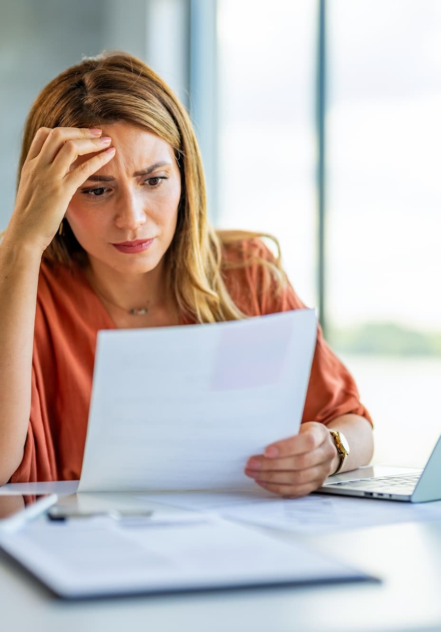 Femme inquiète face à ses papiers