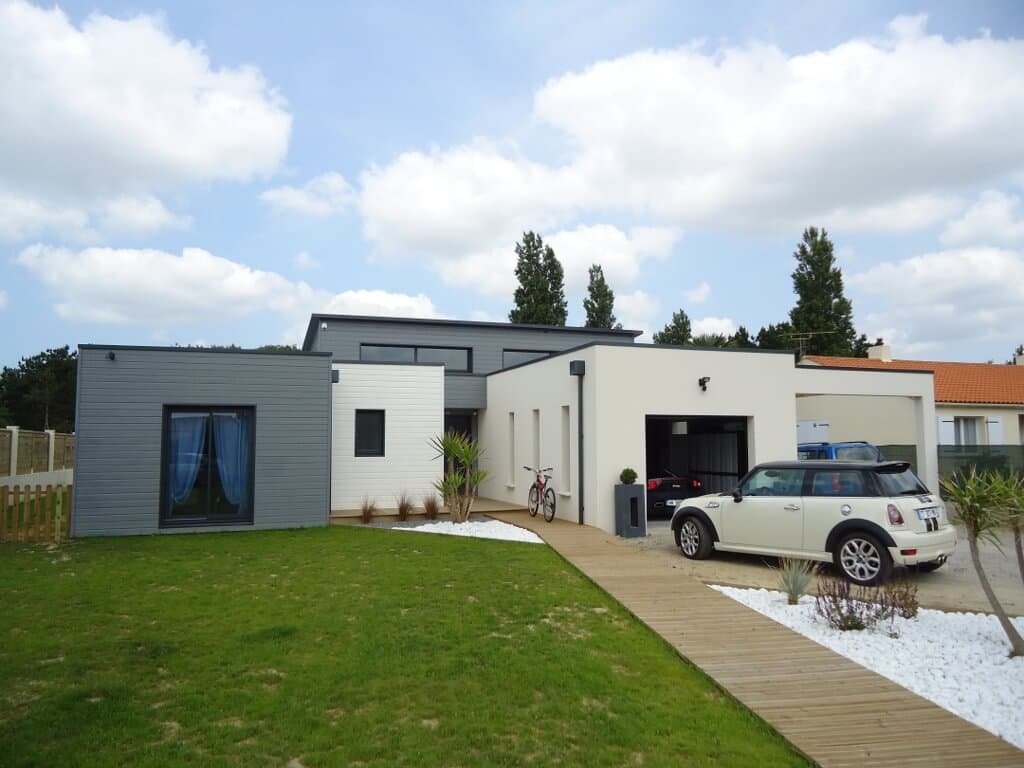Maison en bois sur mesure d'inspiration moderne, volumes enduits et bardage gris