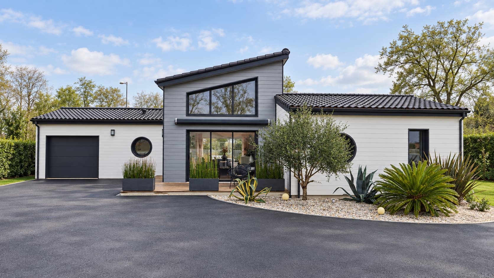 Maison bois moderne réalisée par Projet Bois avec bardage gris et grandes baies vitrées