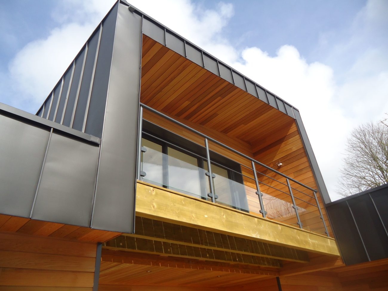 Façade en bardage bois d'une maison vue en contre-plongée