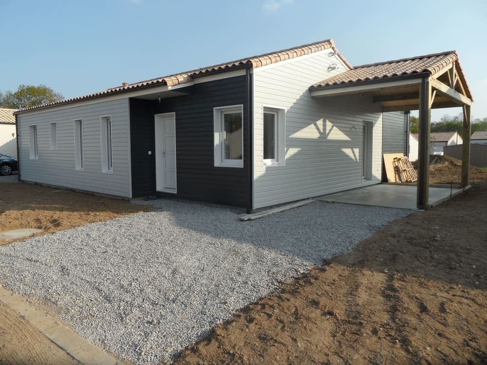 Carport en bois réalisé par Projet Bois à côté d'une maison neuve
