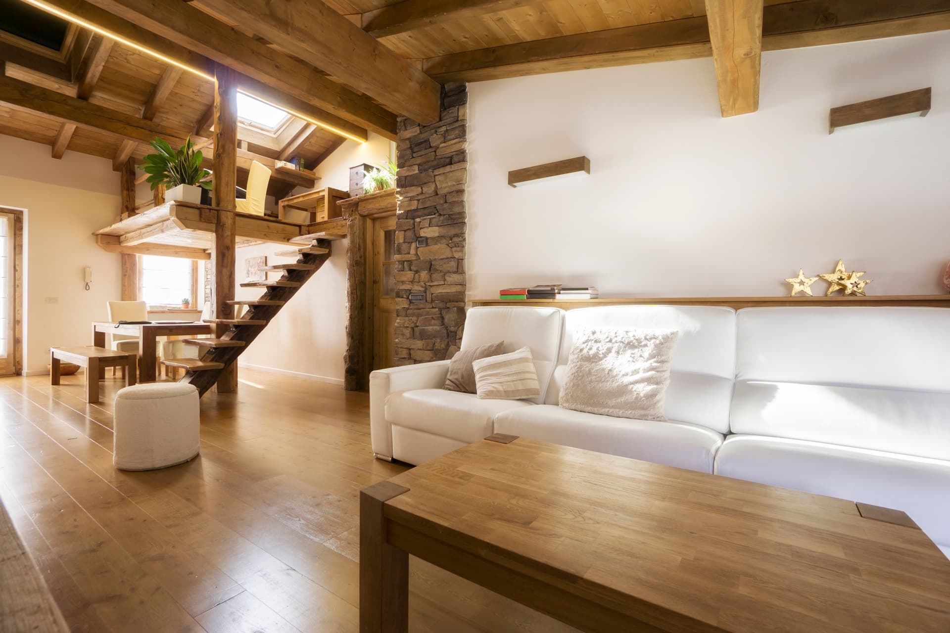 Intérieur chaleureux d'une maison en bois avec poutres et escalier