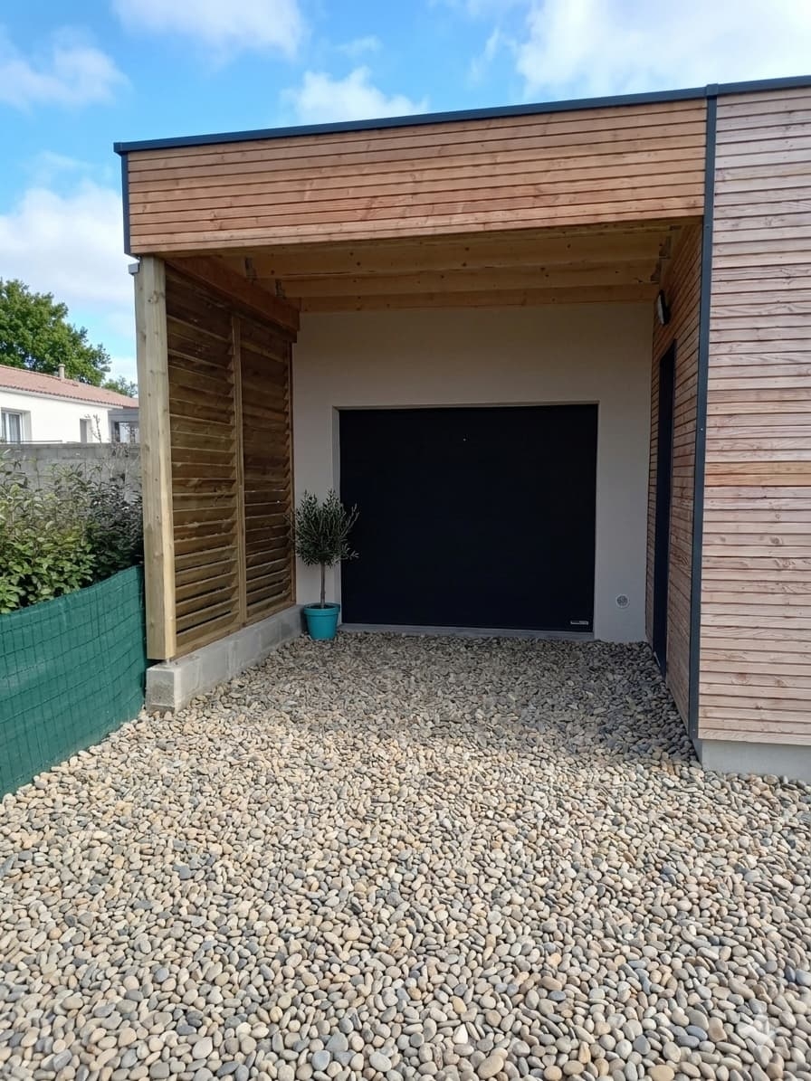 Carport abri en bois à toiture plate devant un garage