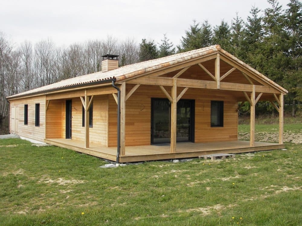Chalet en bois avec toiture pentue, débords de toit et terrasse couverte