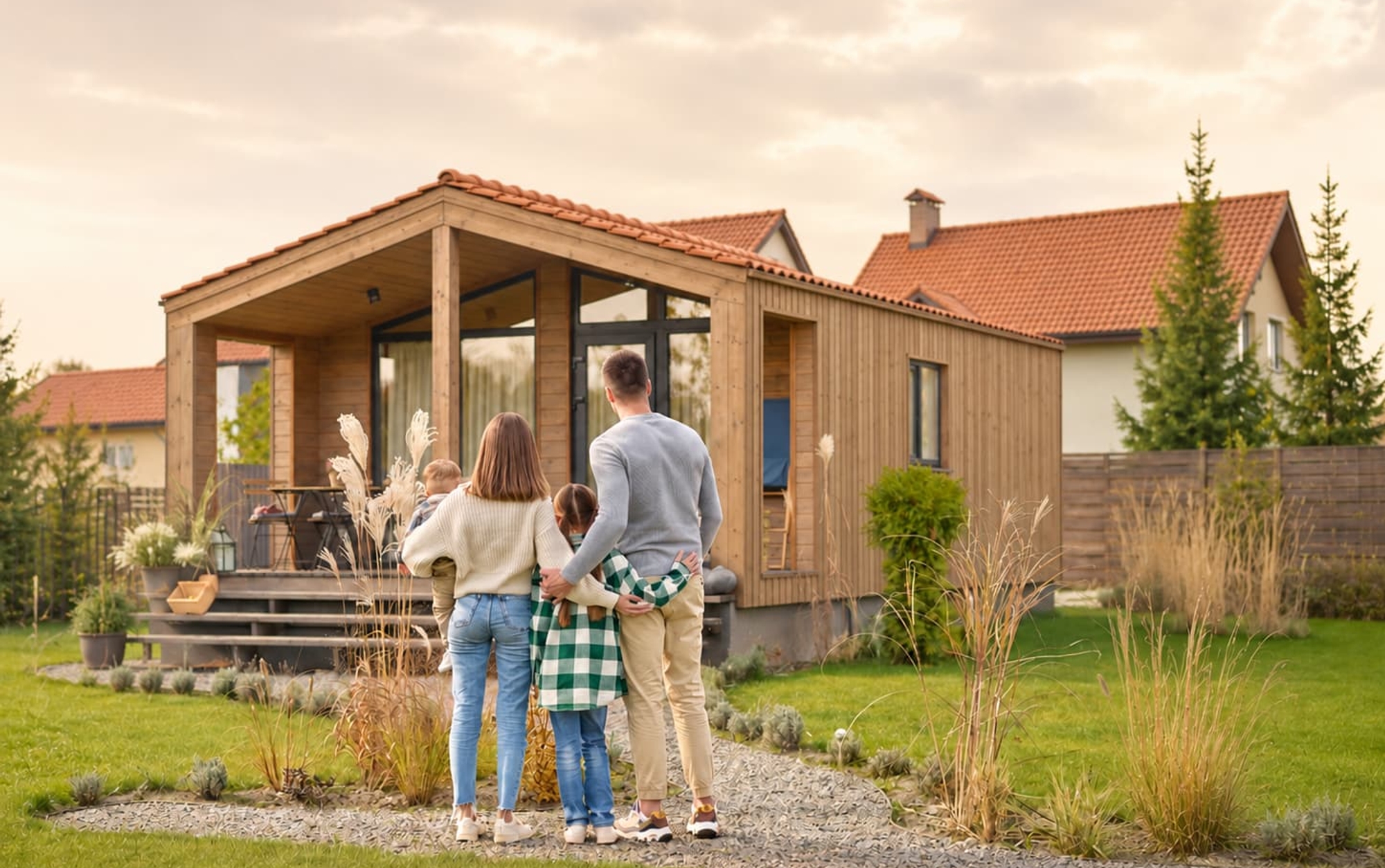 Famille devant sa nouvelle maison en bois