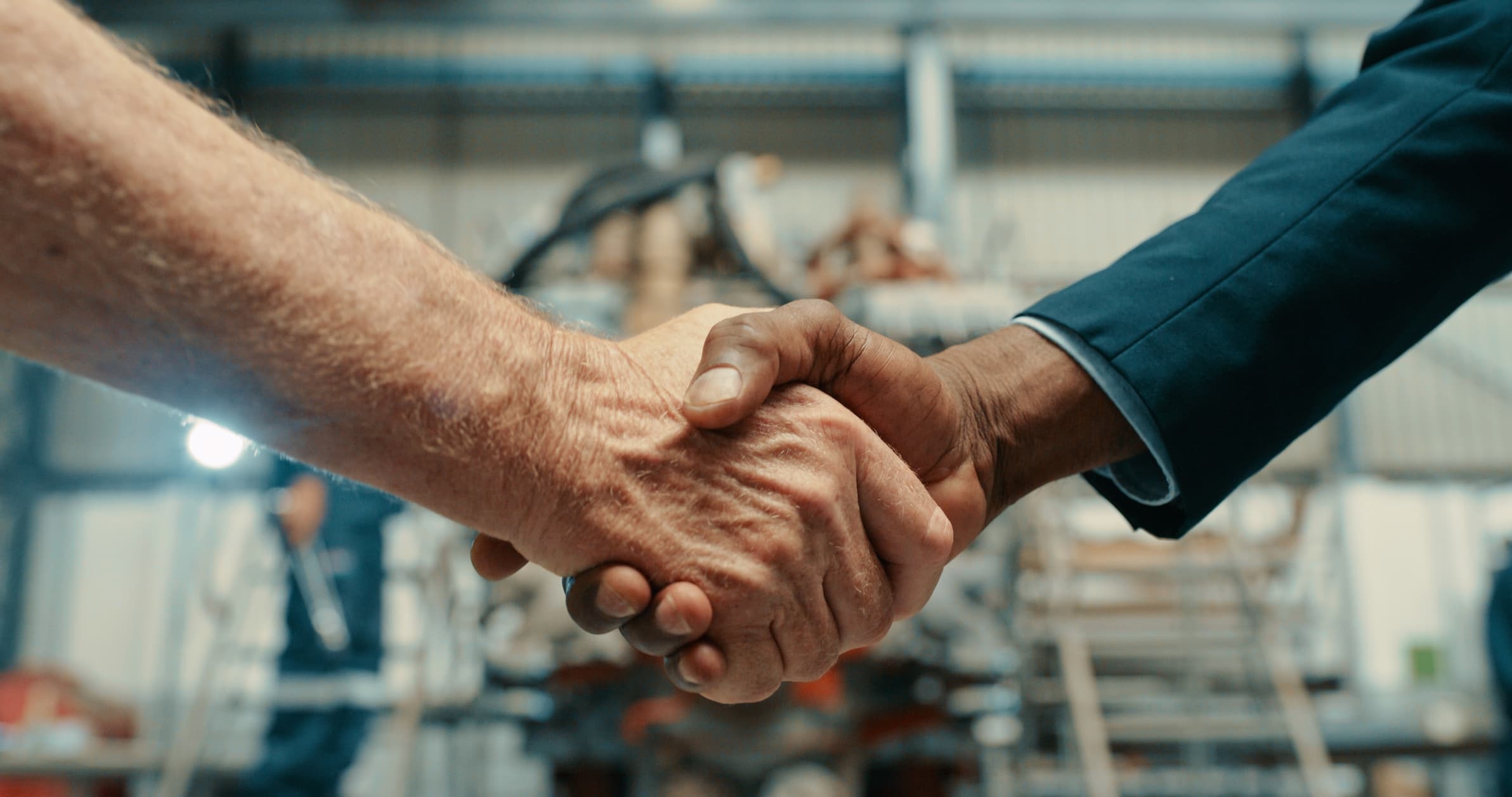 Gros plan sur une poignée de main entre deux artisans