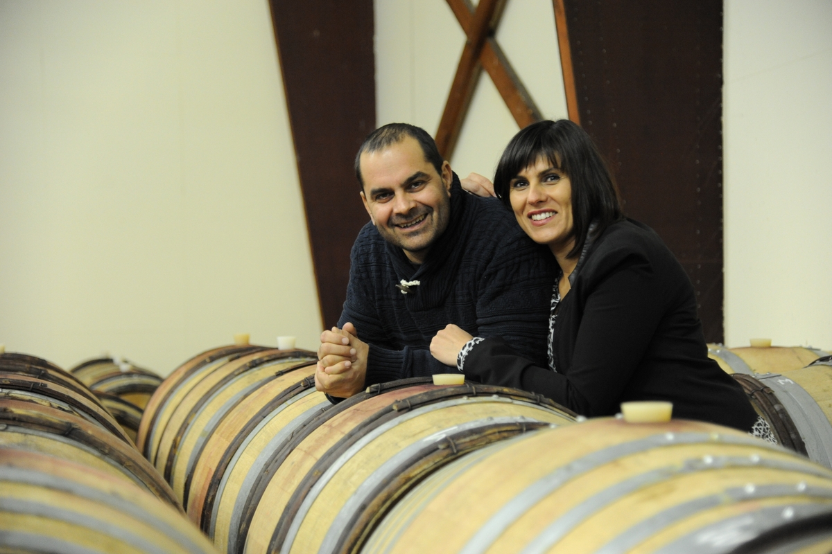 Estelle et Rodolphe Cognard accoudés aux barriques du chai