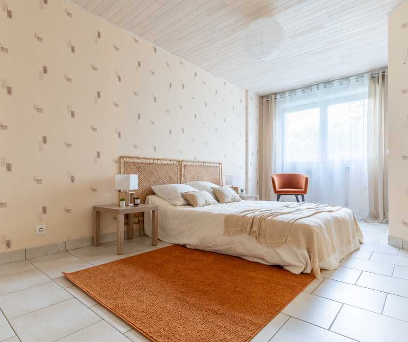 installation d'un lit, tapis et fauteuil pour rendre la chambre plus chaleureuse grace au home staging a coueron