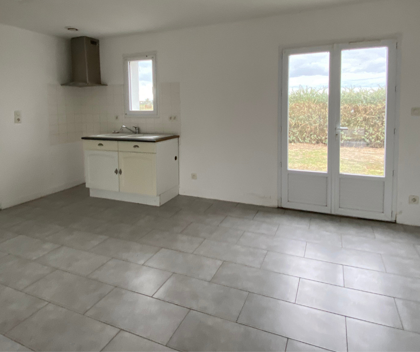Pièce lumineuse avec coin cuisine et carrelage gris avant home staging à Bouin en Vendée