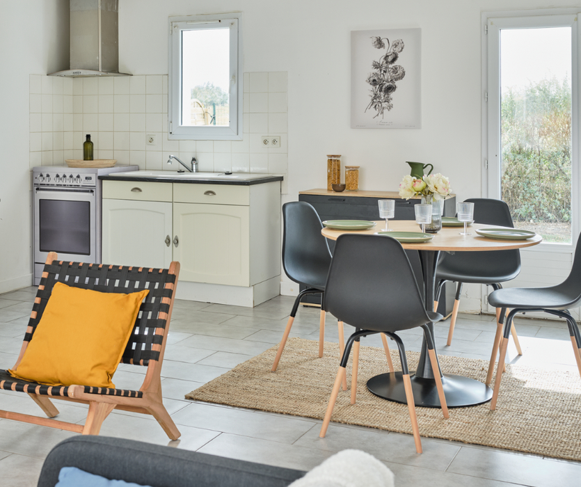 Pièce de vie aménagée avec table chaises fauteuil déco et four factice en carton après home staging à Bouin en Vendée