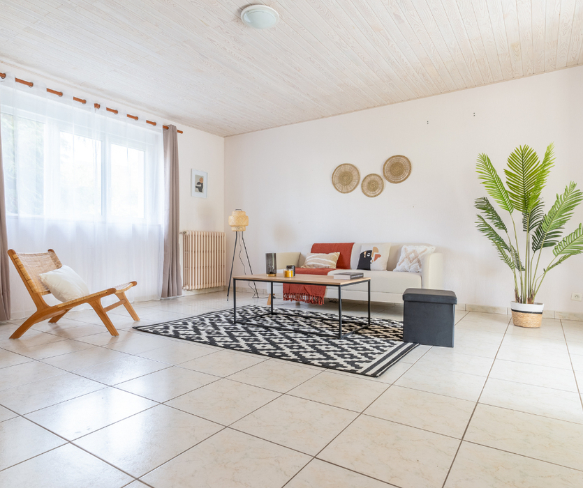 Salon mis en scène avec l'ajout d'un canape tapis table basse fauteuil dans le home staging pour la vente d'une maison a coueron