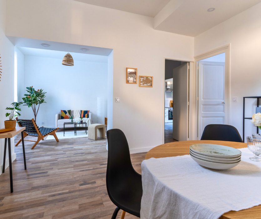 Home staging a La Baule piece de vie meublée avec espace salon canape fauteuil et espace repas table chaise vaisselle