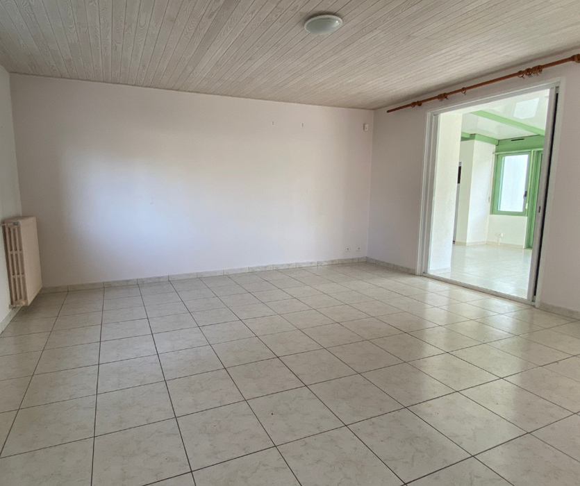piece de vie ouverte sur veranda avec carrelage beige vide pour la vente avant home staging a coueron