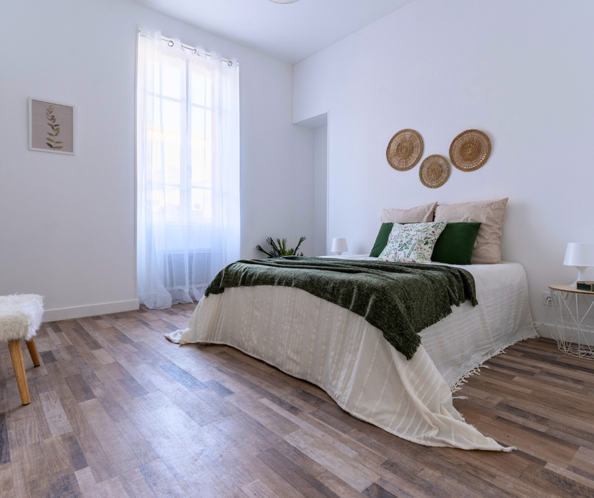 Home staging a La Baule Chambre meublée et décorée avec lit plaid coussins banc table lampe voilages