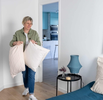 Agnès Augereau avec coussins lors du home staging d'une chambre dans appartement à vendre à nantes