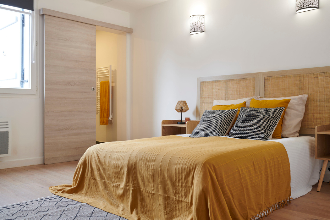 Suite parentale meublée et décorée grâce à l'ajout d'un lit, tables de chevet, plaid coussins avec salle d'eau attenante  après home staging à Pornichet