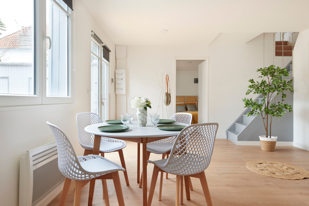 Exemple de valorisation du séjour avec l'installation dune table chaises vaisselle plante et tapis grâce au home staging à Pornichet