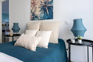 Home staging dans chambre avec lit coussins deco murale