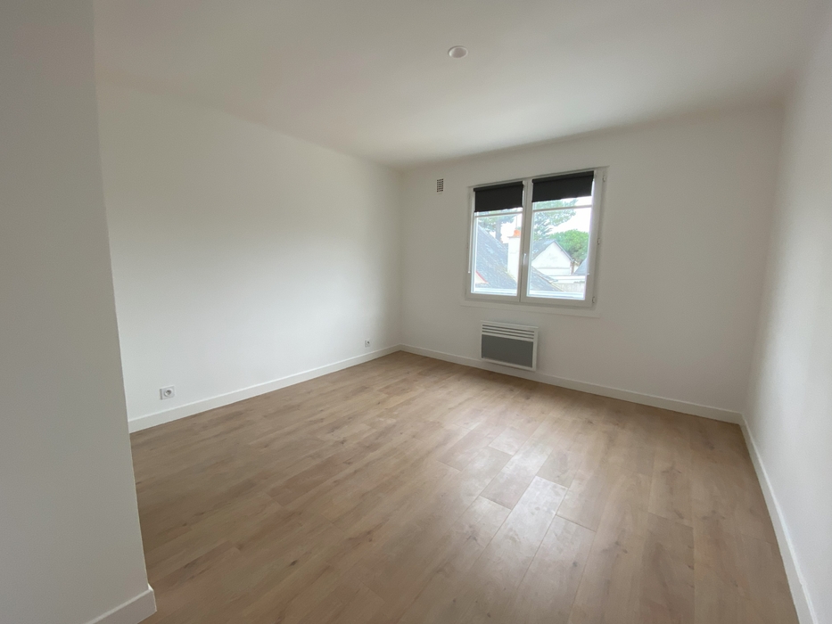 Dans une maison rénovée, chambre avec murs blancs, parquer et fenêtres avec stores vide  avant home staging à Pornichet