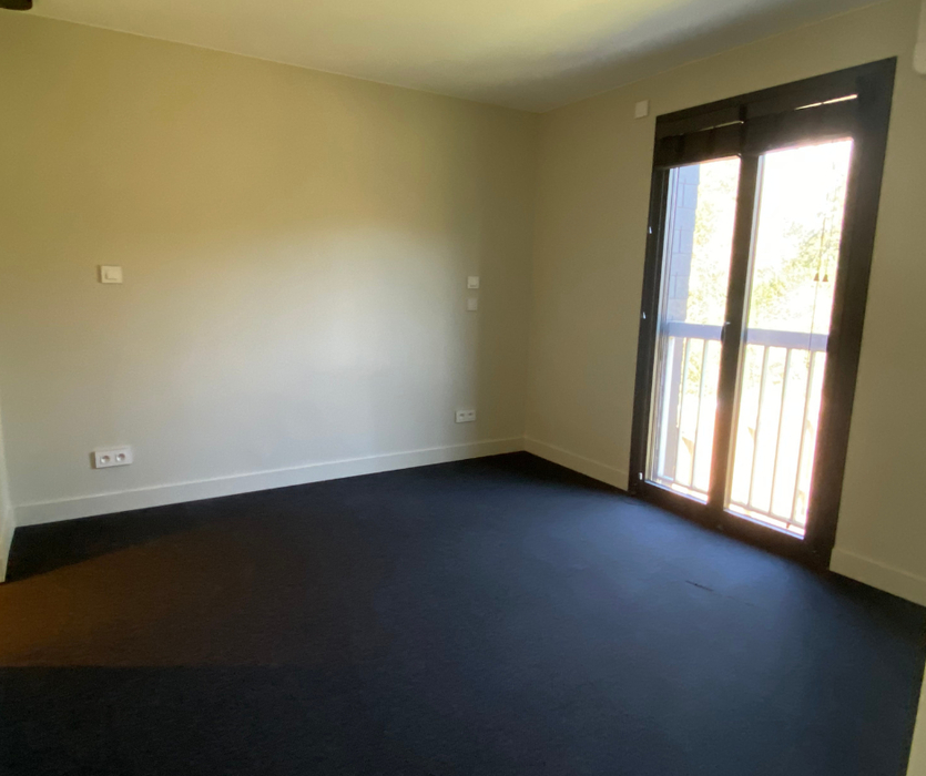 Chambre avec moquette foncée murs beige vide avant home staging à Nantes
