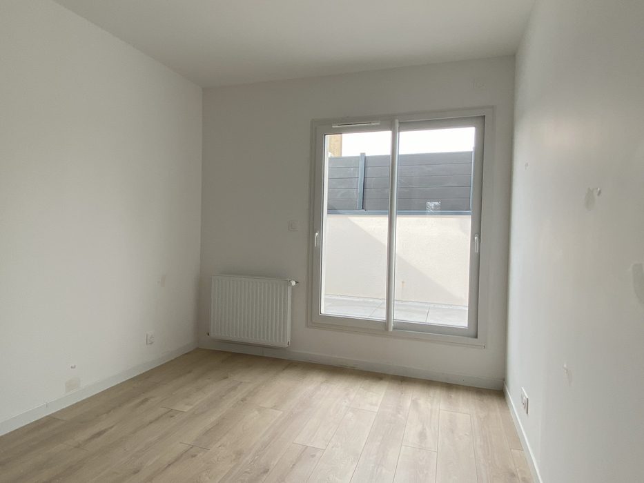 Home staging Orvault Chambre vide avec murs blancs, parquet, porte fenêtres dans maison neuve