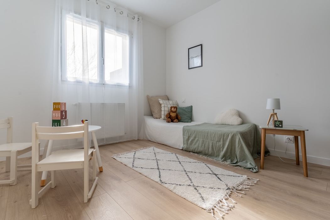 Home staging Orvault Chambre enfant meublée avec lit, table, tapis, chaises, jouets, peluche