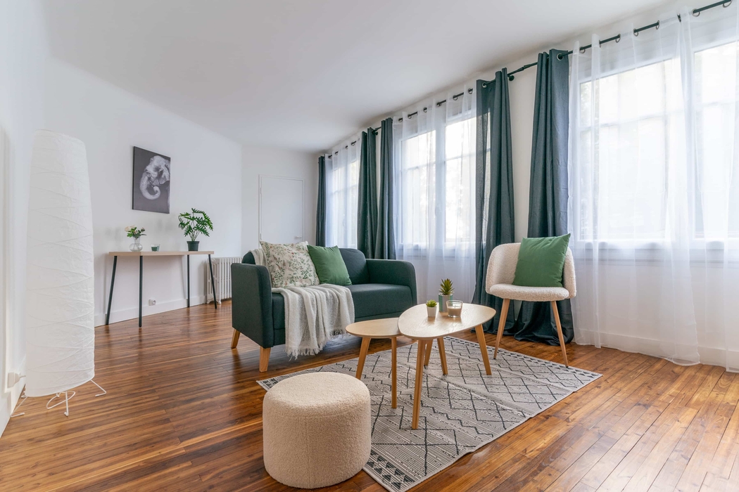 salon meublé grâce au home staging à Nantes avec canapé, fauteuil, table basse, tapis, pouf, rideaux console cadre 