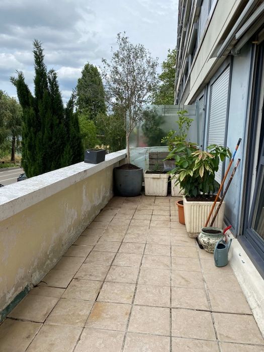 Terrasse avant home staging à Nantes. Encombrée de bacs, balais, pots, arrosoir et sale