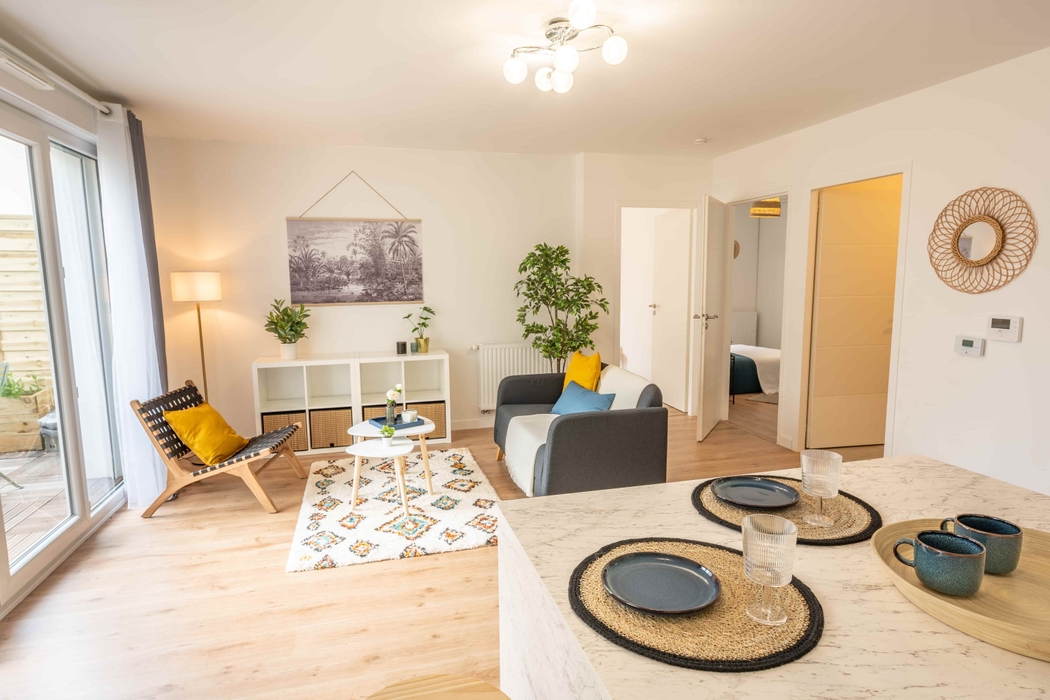 Grand séjour aménagé et décoré pour la vente avec l'ajout de canapé fauteuil tapis meuble de rangement vaisselle après home staging à Nantes quartier Chalatres