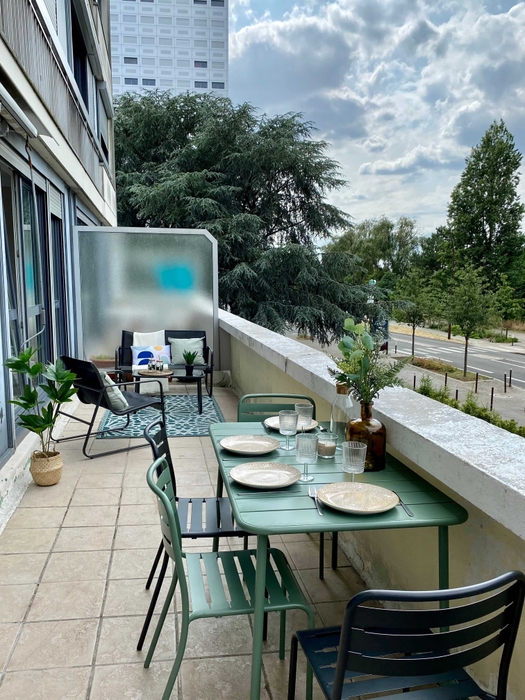 terrasse mise en scène apres home staging à Nantes. Coin salon avec canapé tapis fauteuil coussins. Coin repas avec table chaises vaisselle déco