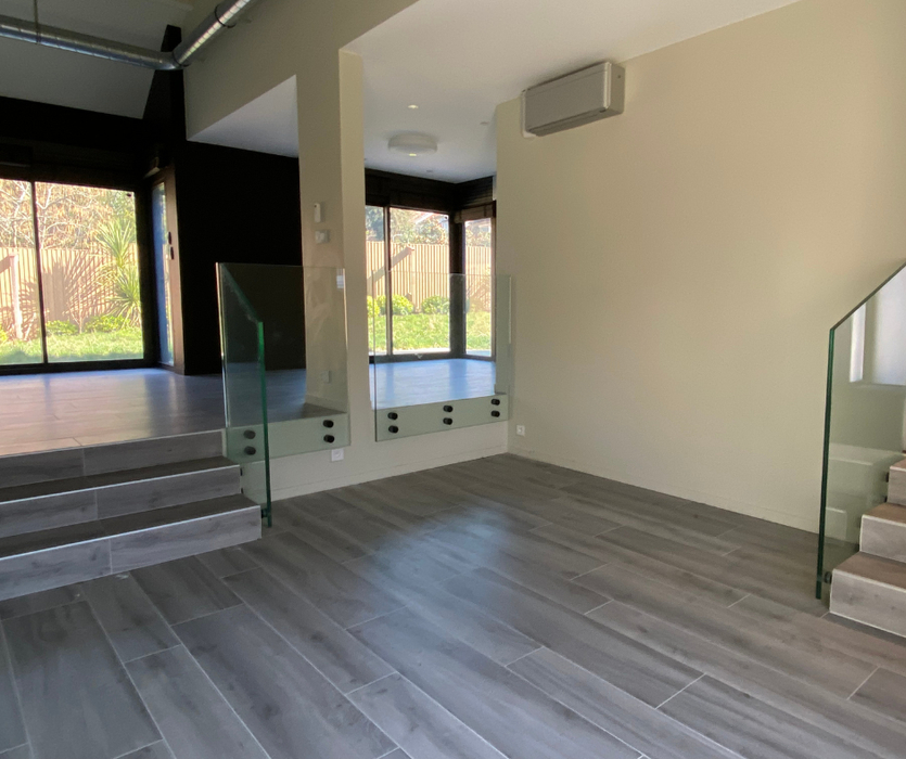 Salon en demi niveau vide parquet murs beige  avant home staging à Nantes