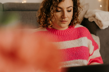 Clothilde, assistante indépendante CloAssist', travaille sur son ordinateur portable dans un canapé